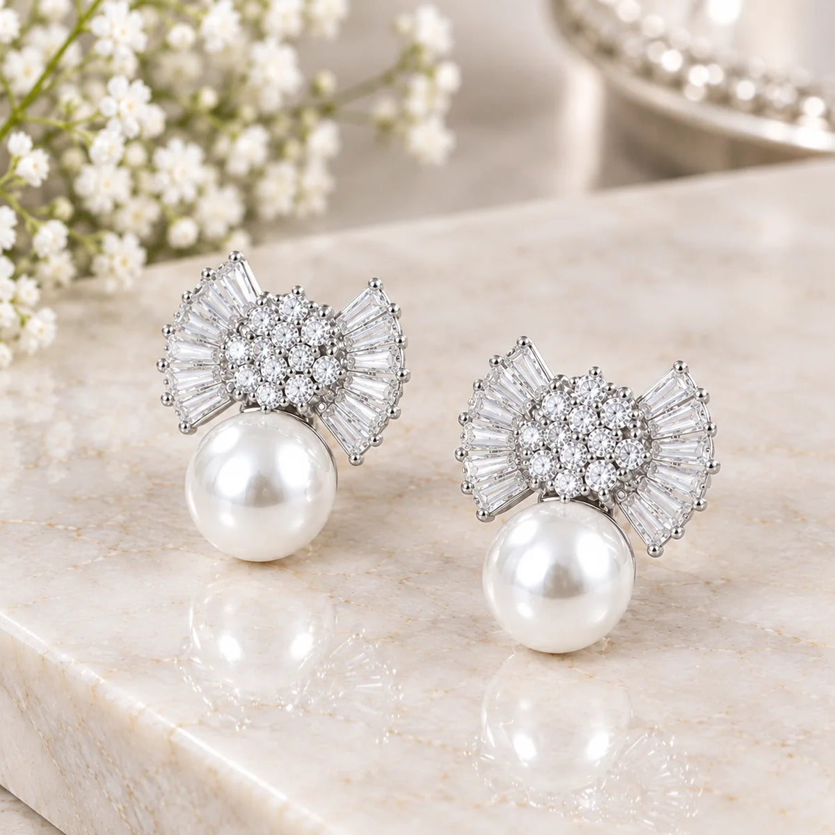 Silver bow earrings with large pearl drops