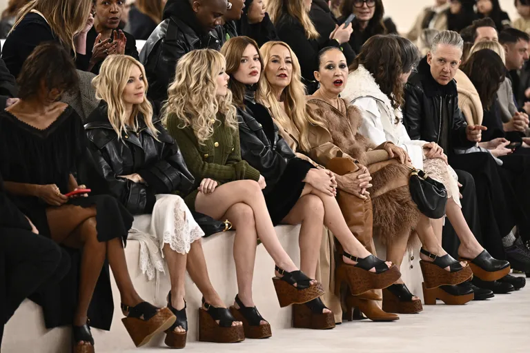 "Fashion show front row guests wearing chunky platform wedge heels and luxury outfits"