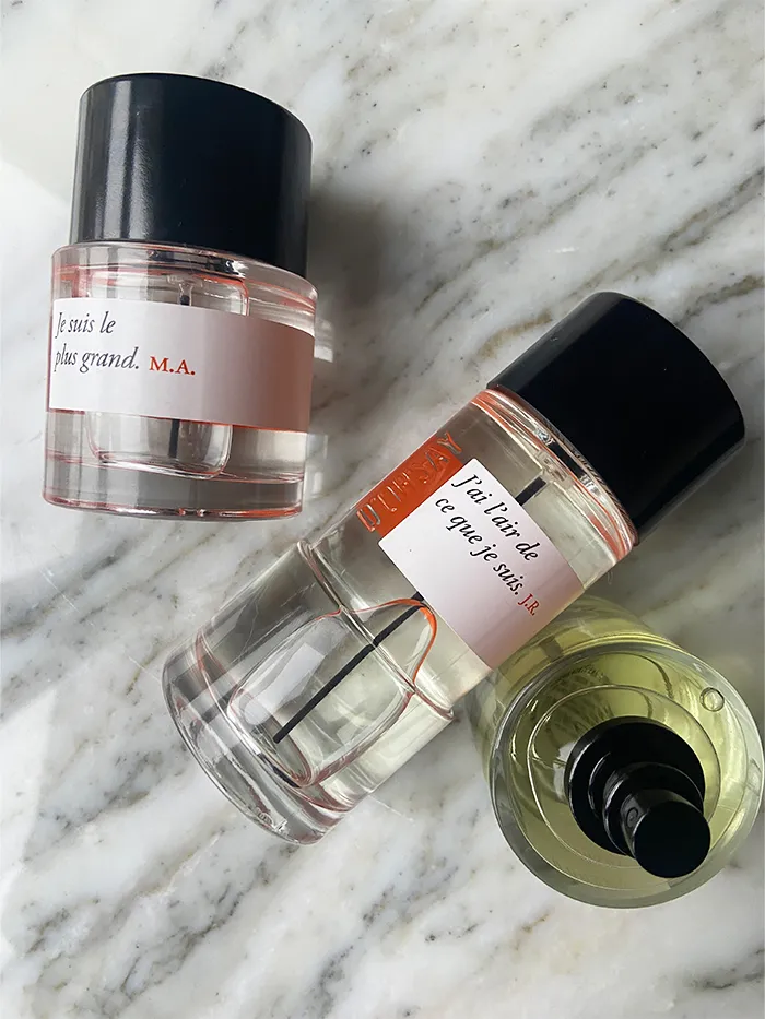 D’Orsay perfume bottles displayed on marble surface with minimalist black caps