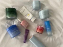 Laneige skincare collection featuring Water Sleeping Mask, Cica Sleeping Mask, Lip Sleeping Mask, sunscreen, serum, and eye cream arranged on soft white fabric background.