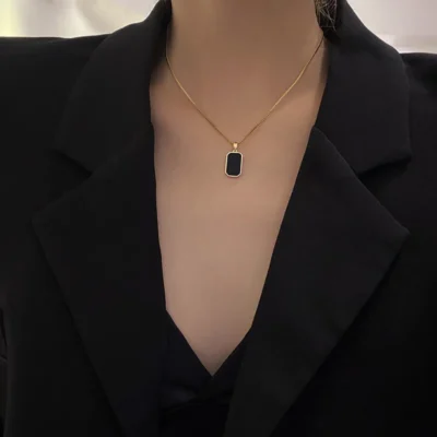 Gold necklace with black and white rectangular pendant