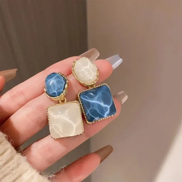 Close-up blue geometric drop earrings elegant design detail