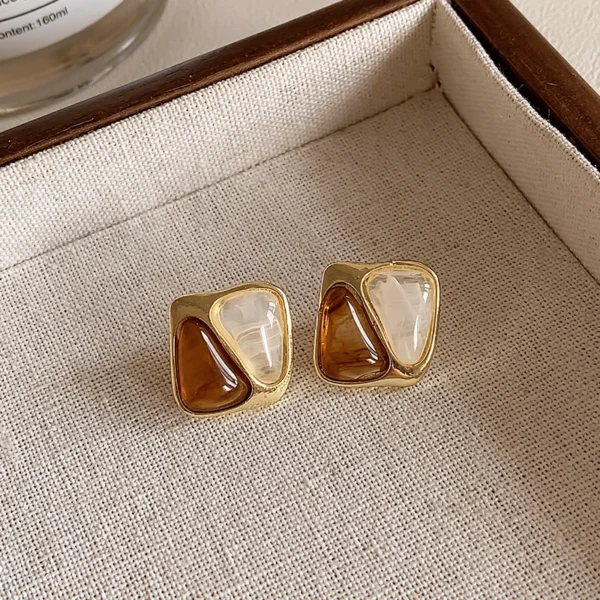 Abstract gold tone stud earrings with caramel resin design