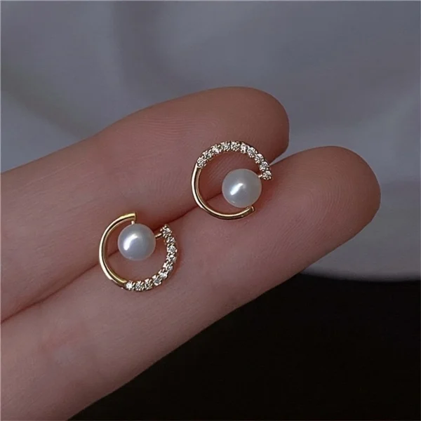Close-up of hollow circle pearl stud earrings with CZ rhinestones