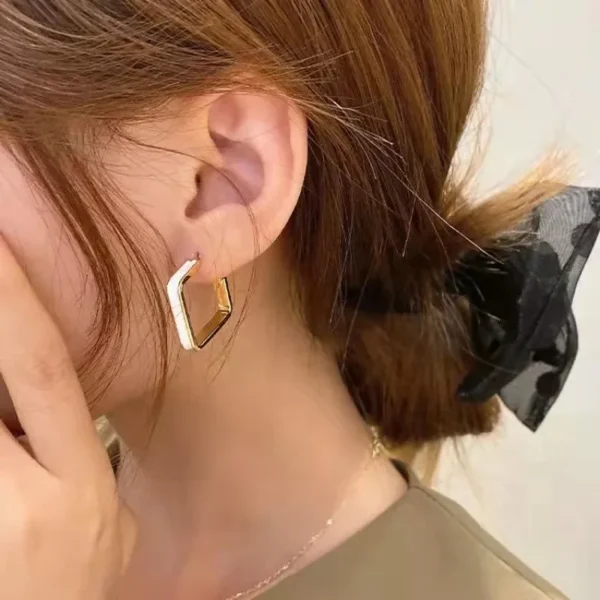 Women wearing black white geometric drop earrings