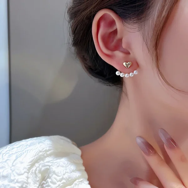 Women wearing pearl heart stud earrings fashion look