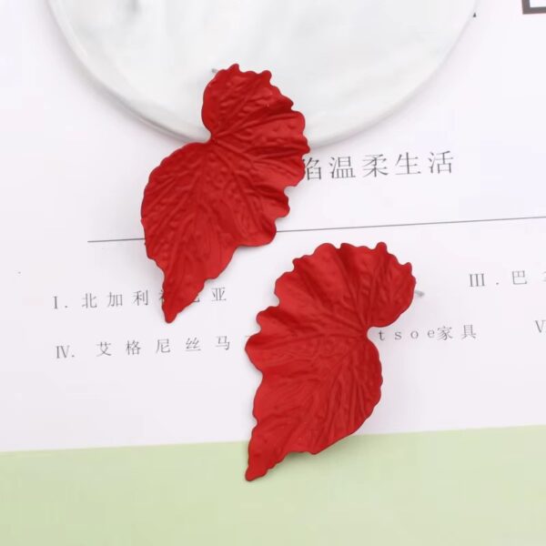 Close-up long metal leaf earrings elegant detail
